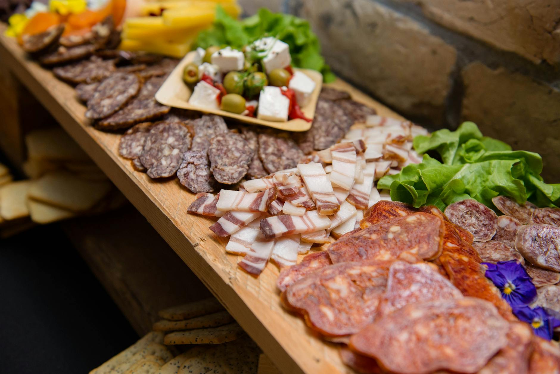 Graisse de porc séchée en tranches appétissantes à angle élevé et saucisses fumées servies sur un buffet avec du fromage et des olives pendant la restauration sous forme de buffet