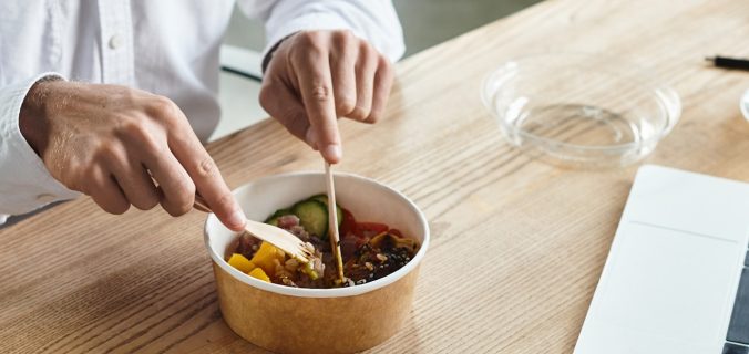 Un homme d'affaires en chemise blanche savoure un déjeuner nutritif tout en se concentrant sur son travail de projet.