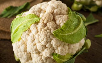 Têtes de chou-fleur bio crues avec des feuilles vertes fraîches