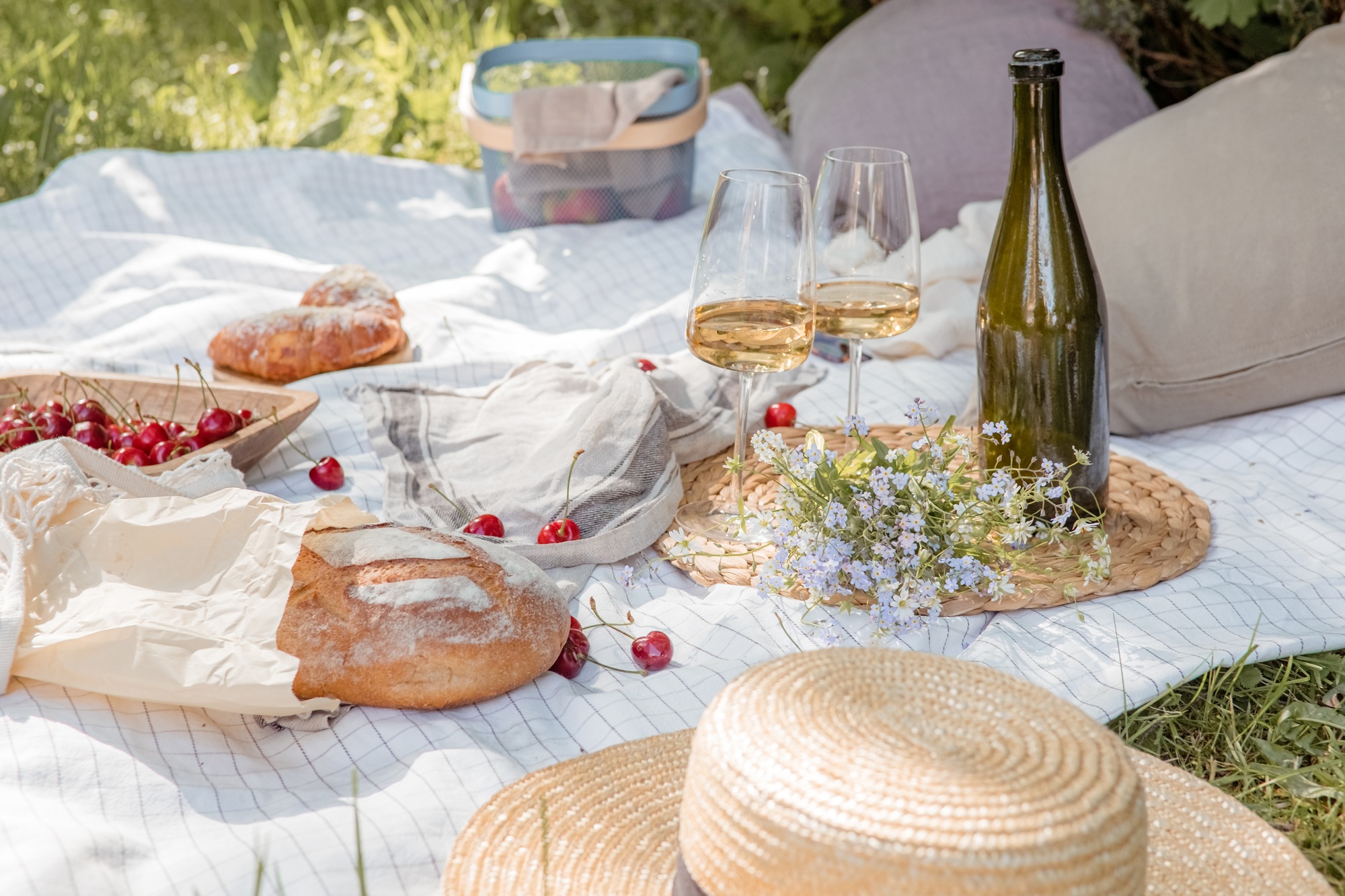Pique-nique esthétique à l'extérieur avec des verres à vin Baies et fleurs de pain.