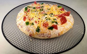 Les légumes frais ajoutés incluent les tomates et les poivrons ajoutés à la pizza au fromage congelé.