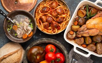 Table à manger avec plats traditionnels de savoureux maison: soupe de poulet, boulettes de viande avec spaghettis, poulet rôti avec pommes de terre.