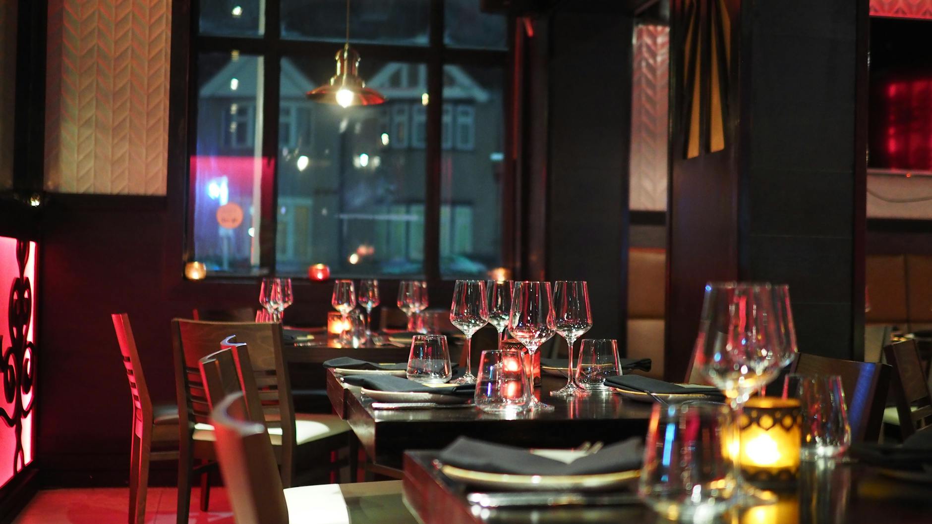 Un intérieur de restaurant sophistiqué avec un cadre de table élégant et une lutte aux chandelles ambiantes, créant une atmosphère confortable.