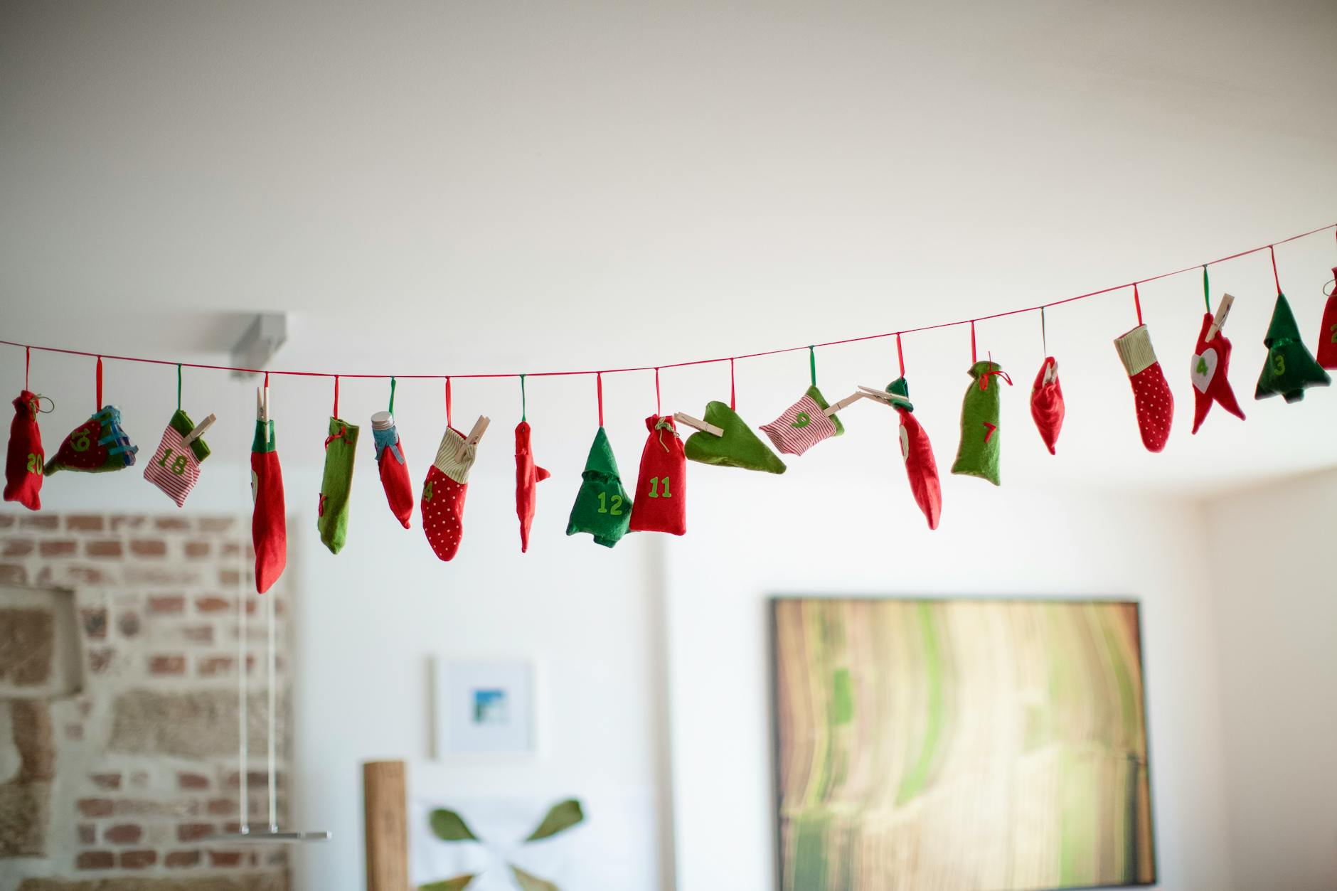 Un calendrier de l'Avent en tissu festif avec des sacs colorés suspendus à l'intérieur.