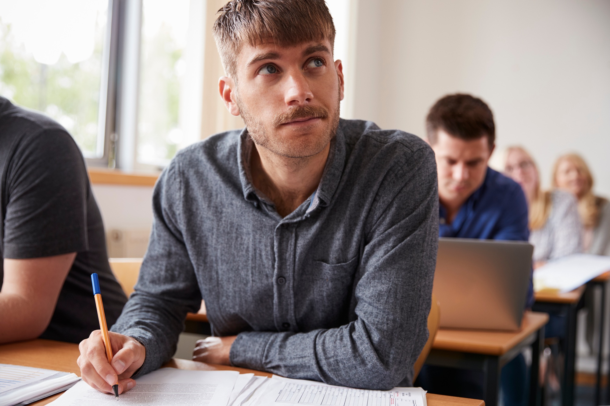 Étudiant masculin mature qui assiste à un cours d'éducation pour adultes