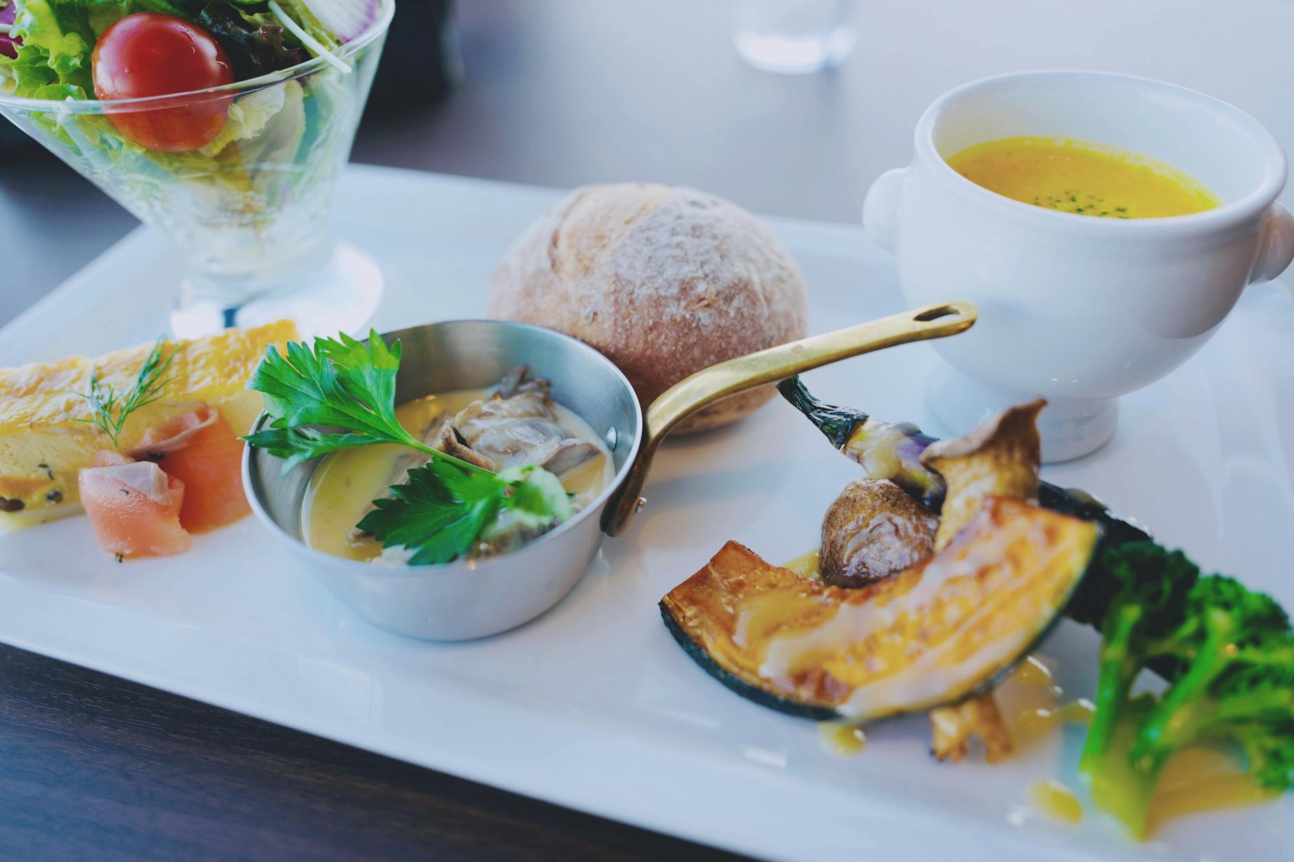 Un petit-déjeuner japonais magnifiquement présenté avec une salade fraîche et des légumes de saison.
