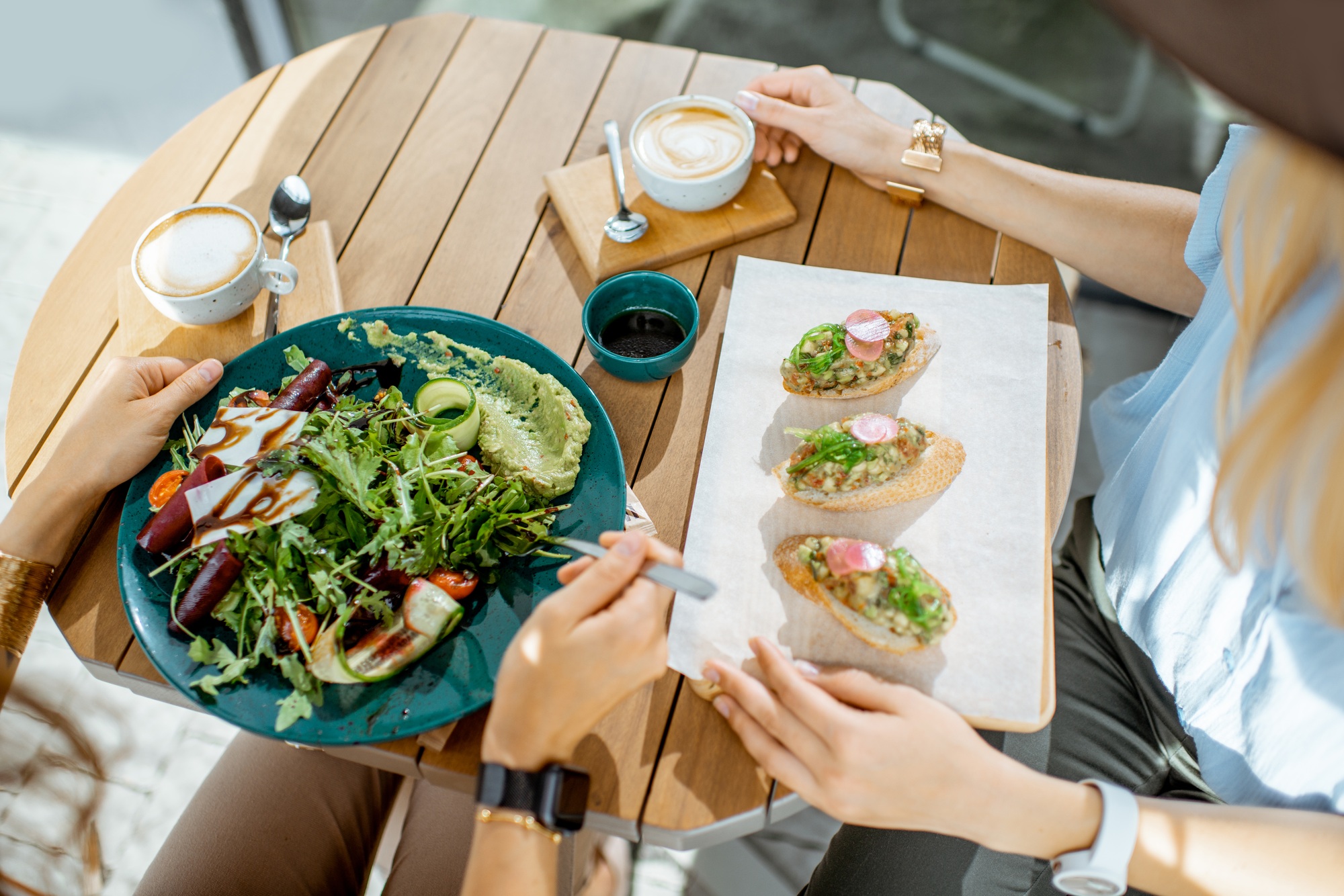 Les femmes mangeant des aliments végétariens sains au café, vue rapprochée d'en haut sur la table