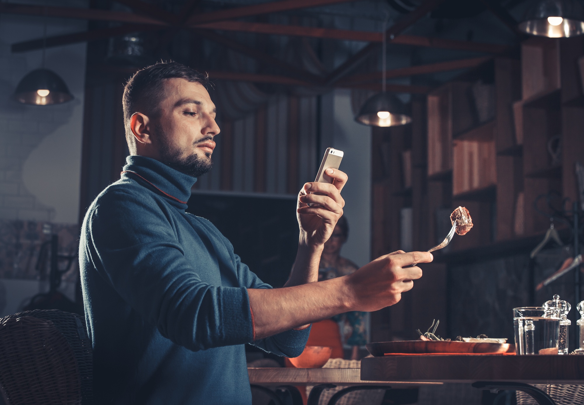 Beau homme photographier de la nourriture au restaurant