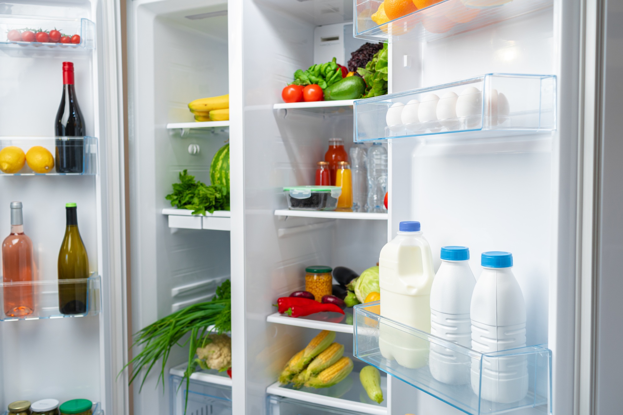 Réfrigérateur ouvert plein de fruits frais, légumes et boissons