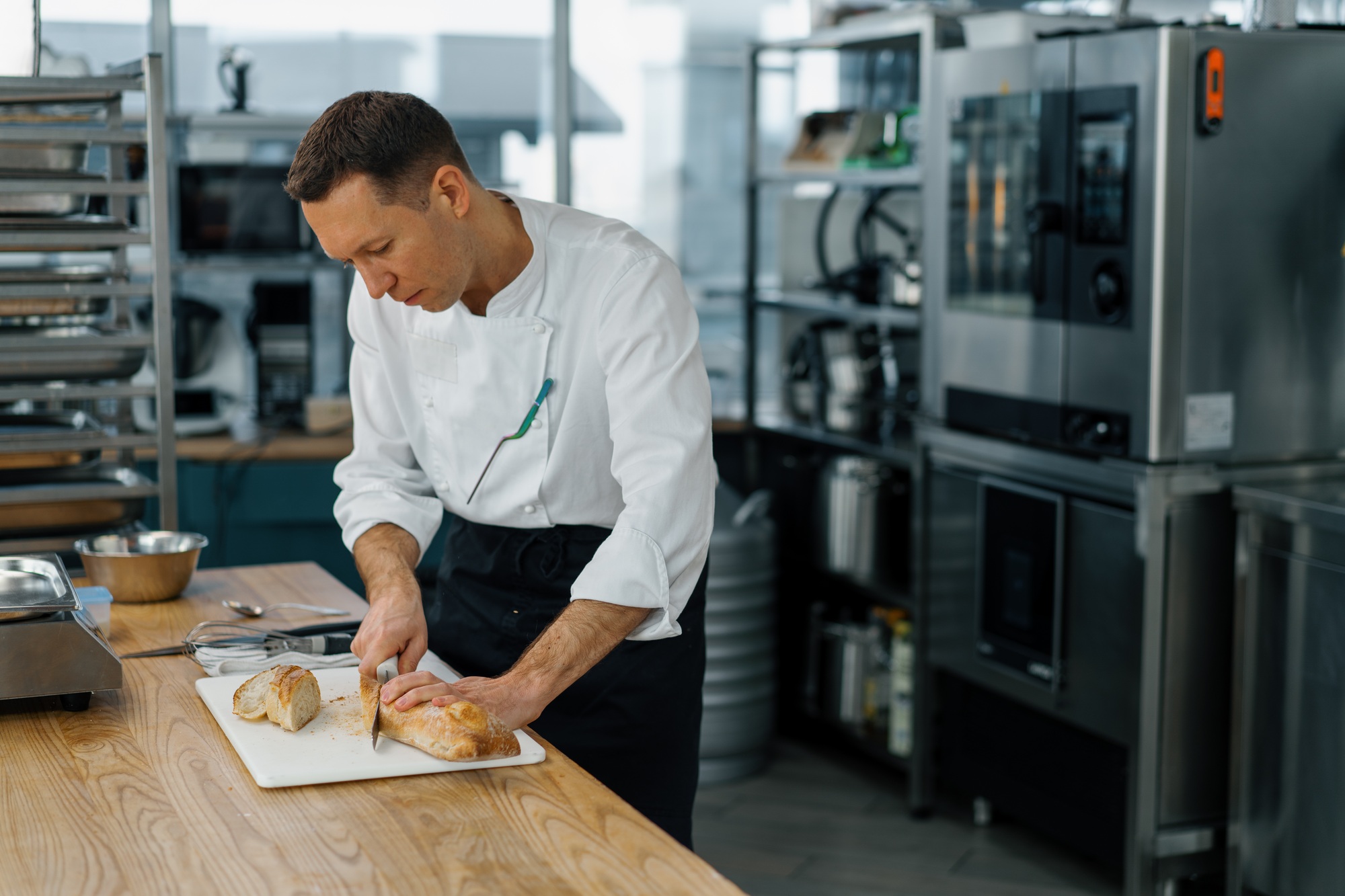 Cuisine moderne professionnelle dans le restaurant Coupte le pain prêt à la cuit au four de toast au four avec un couteau