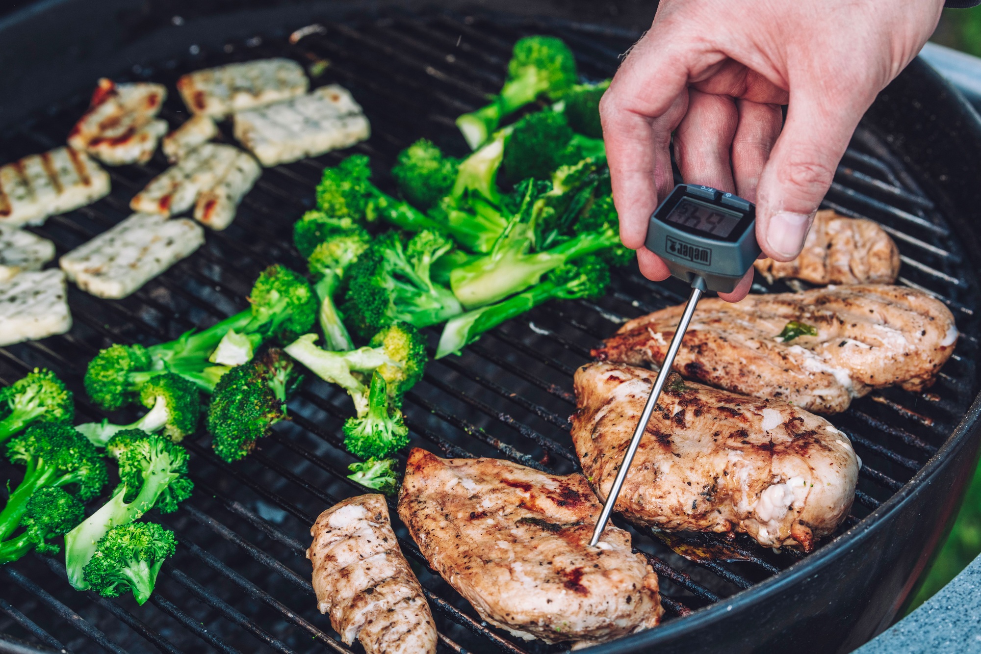 Un homme mesurant la température du steak avec un thermomètre à viande