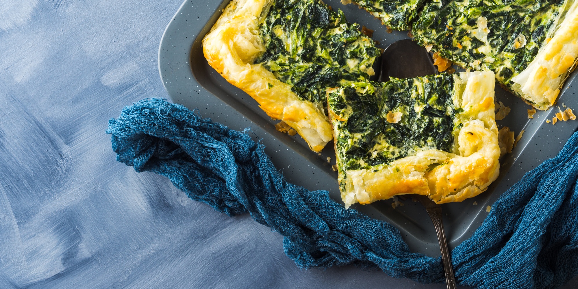 Quiche salée d'épinards avec fromage à la crème sur plateau de cuisson