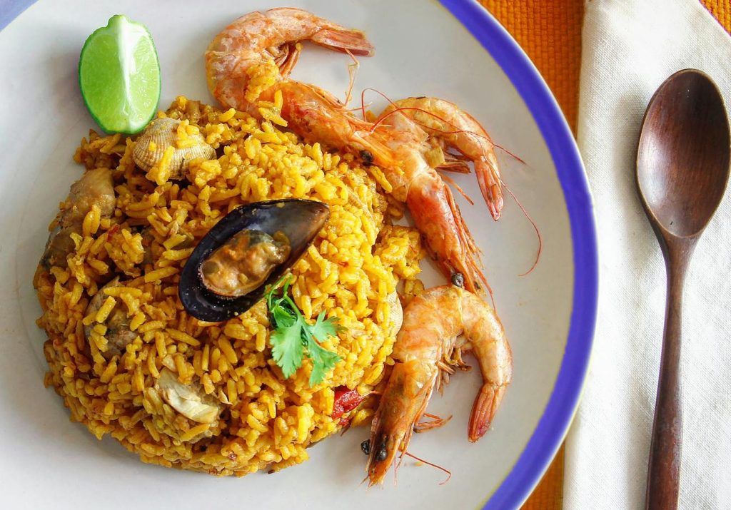 Gros plan d'une paella de fruits de mer traditionnelle aux crevettes et au citron vert, parfait pour les amateurs de nourriture.