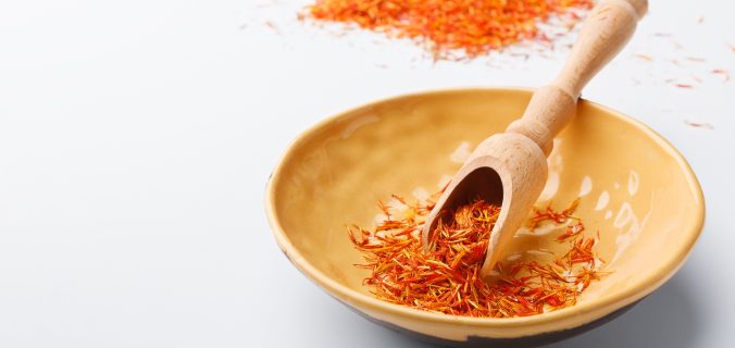 Épices de safran sec traditionnelles dans une assiette sur table blanche avec un espace de copie