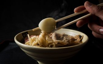 Gros plan sur d'authentiques nouilles ramen avec un œuf dur et des baguettes. Idéal pour les passionnés de gastronomie.
